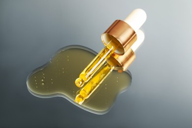 Photo of Yellow serum with pipette on mirror, closeup