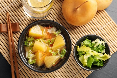 Photo of Bowl of tasty turnip soup served on table, flat lay