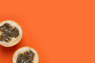 Photo of Halves of delicious ripe granadilla on orange background, flat lay. Space for text