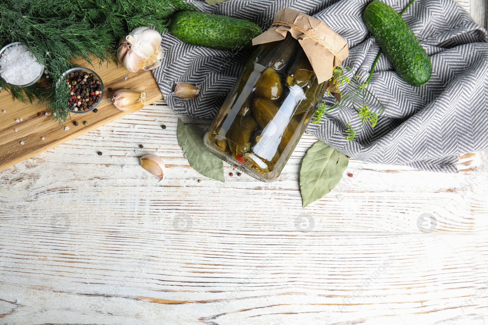 Photo of Flat lay composition with jar of pickled cucumbers on white wooden table, space for text