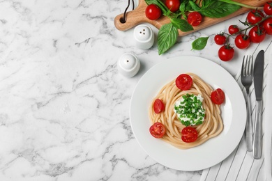 Photo of Delicious spaghetti with sour cream dressing on white marble table, flat lay. Space for text