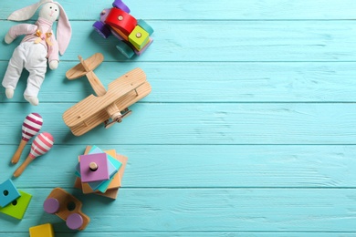 Photo of Different toys on light blue wooden background, flat lay. Space for text