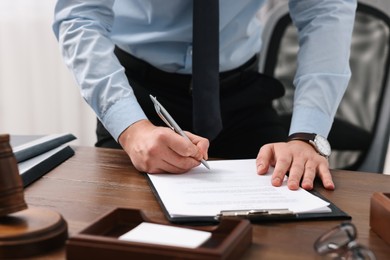 Photo of Lawyer working at wooden table in office, closeup