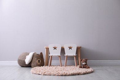 Photo of Cute child room interior with furniture and toy near light grey wall