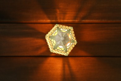 Photo of Decorative Arabic lantern on wooden table, top view