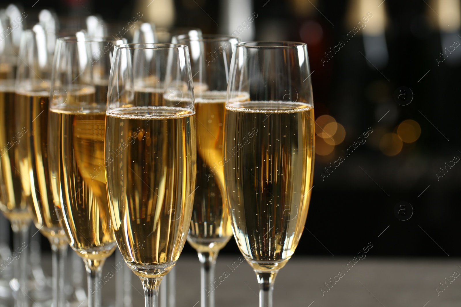 Photo of Many glasses of champagne on blurred background, closeup