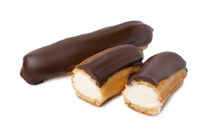 Photo of Cut and whole delicious eclairs covered with chocolate isolated on white