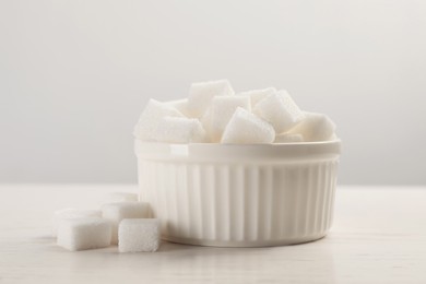 Photo of Bowl with sugar cubes served on white table