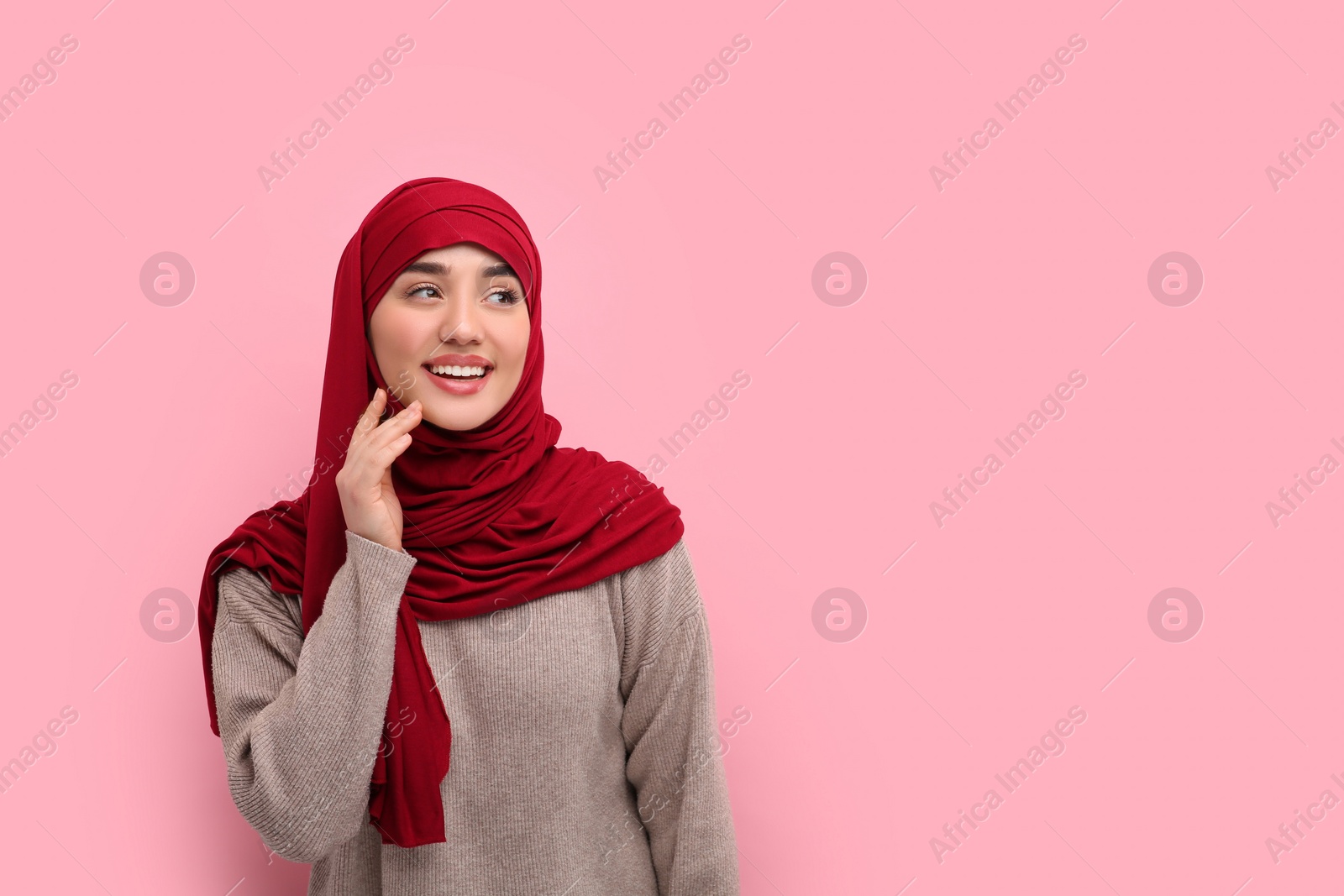 Photo of Portrait of Muslim woman in hijab on pink background, space for text