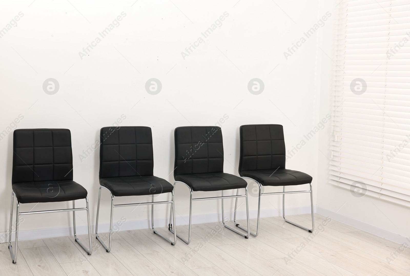 Photo of Many chairs near white wall in waiting area indoors