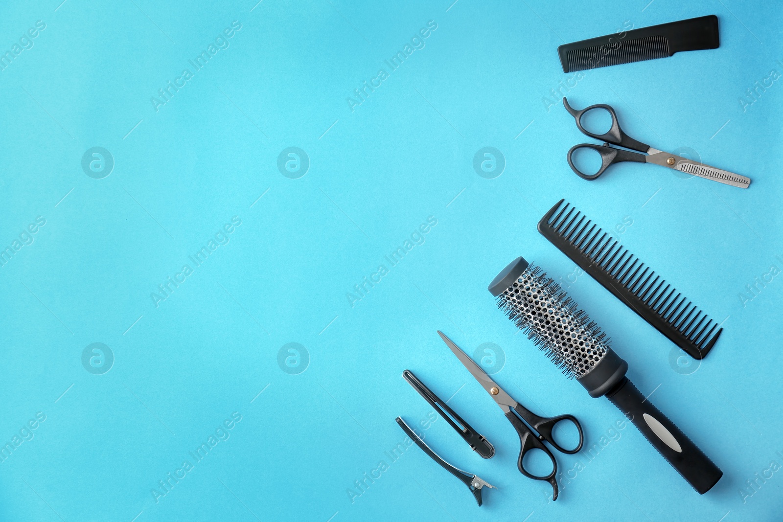 Photo of Flat lay composition with professional hairdresser tools on color background