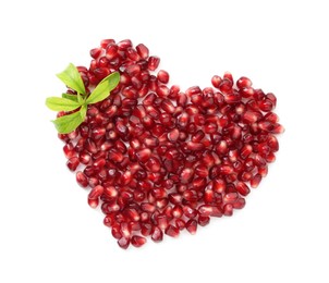 Photo of Heart made of tasty pomegranate grains and green leaves isolated on white, top view