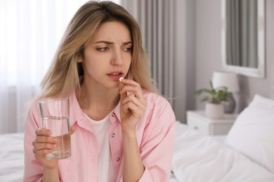 Photo of Upset young woman taking abortion pill at home