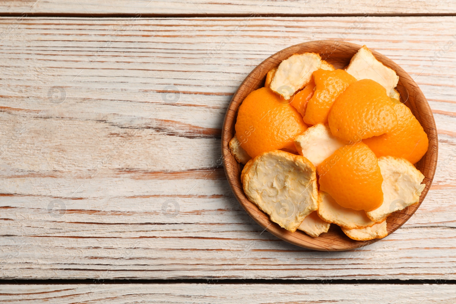 Photo of Orange peels preparing for drying on wooden table, top view. Space for text