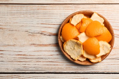 Photo of Orange peels preparing for drying on wooden table, top view. Space for text