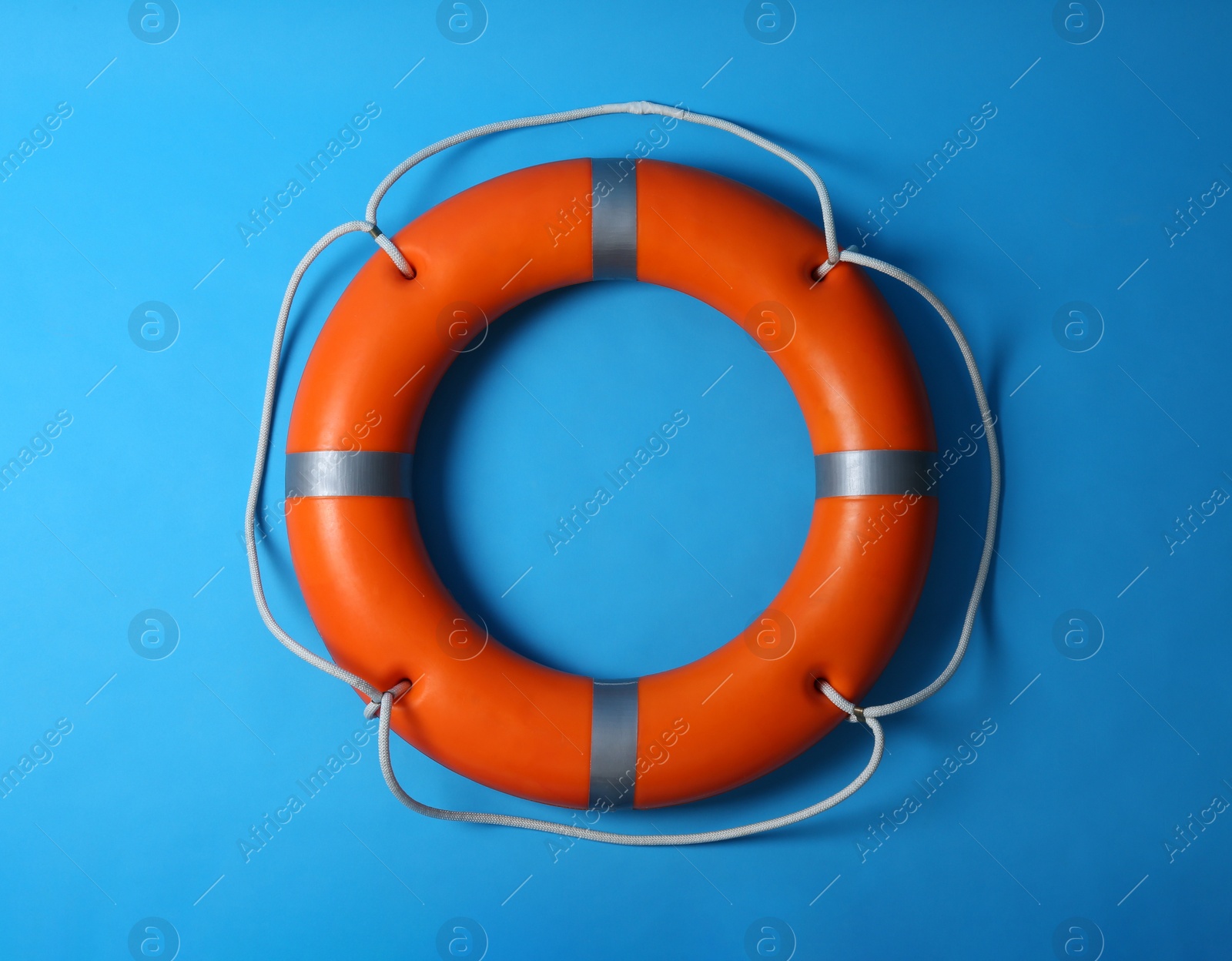 Photo of Orange lifebuoy on blue background. Rescue equipment