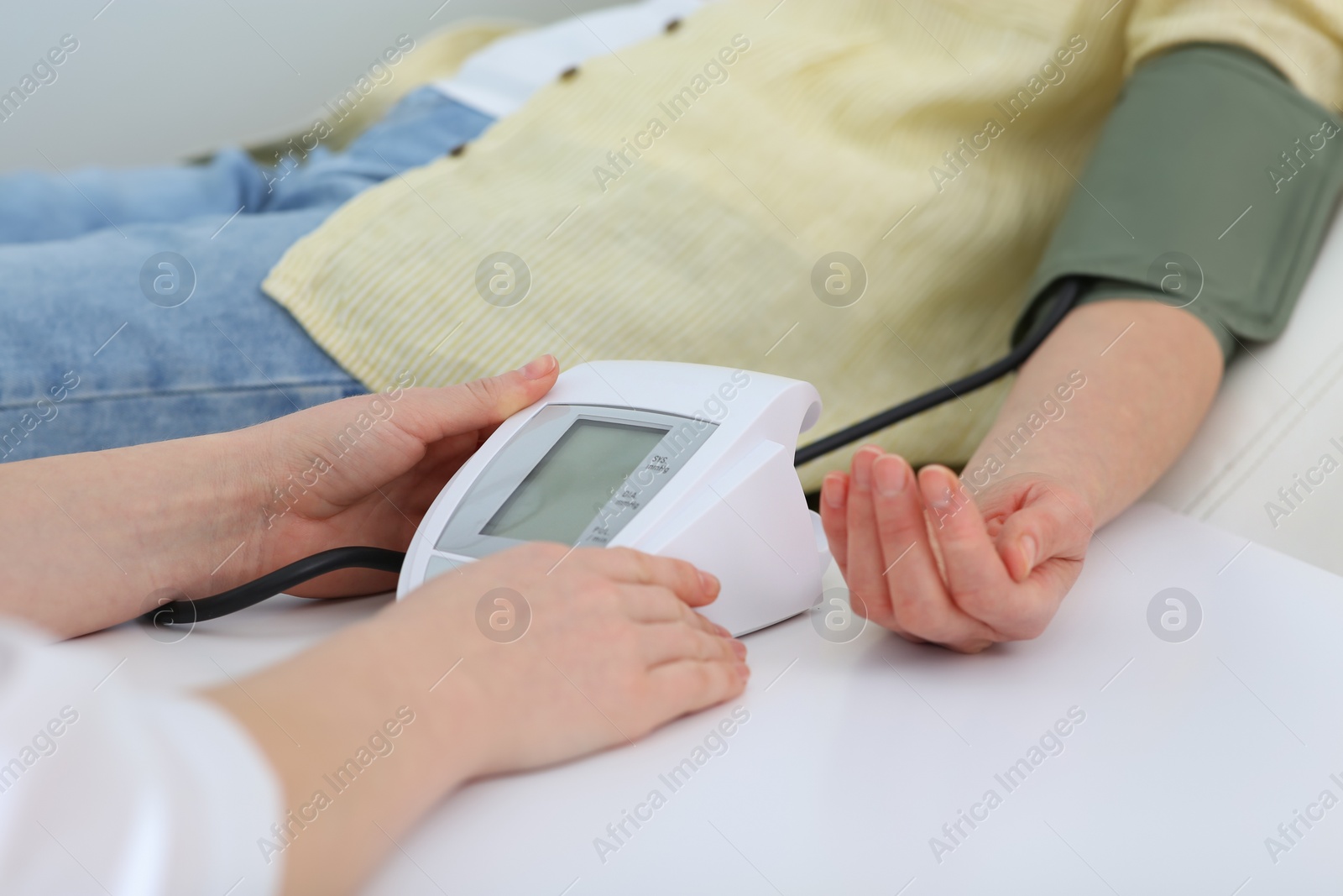 Photo of Doctor checking blood pressure of woman in clinic, closeup