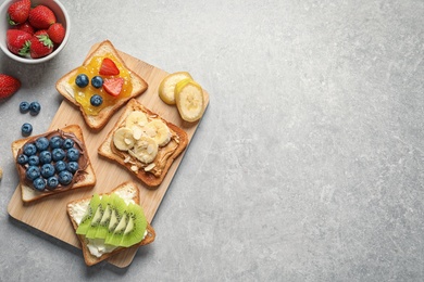 Photo of Flat lay composition with toast bread and different toppings on grey background