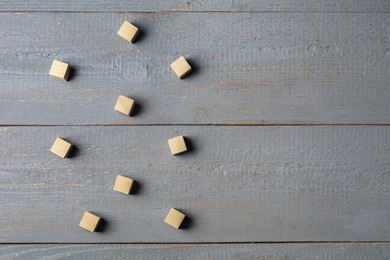 Photo of Blank cubes on light grey wooden table, flat lay. Space for text