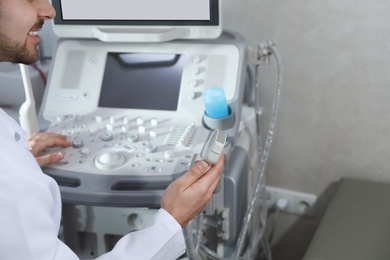 Sonographer using modern ultrasound machine in clinic, closeup