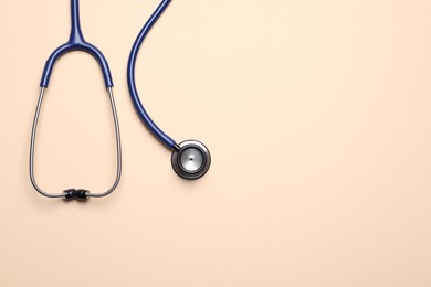 Stethoscope on beige background, top view. Space for text