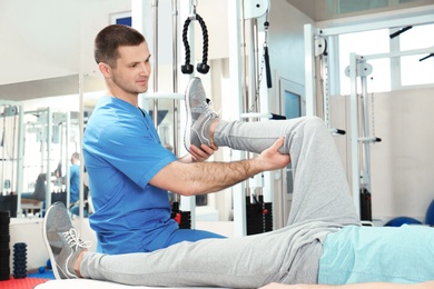 Photo of Physiotherapist working with patient in rehabilitation center