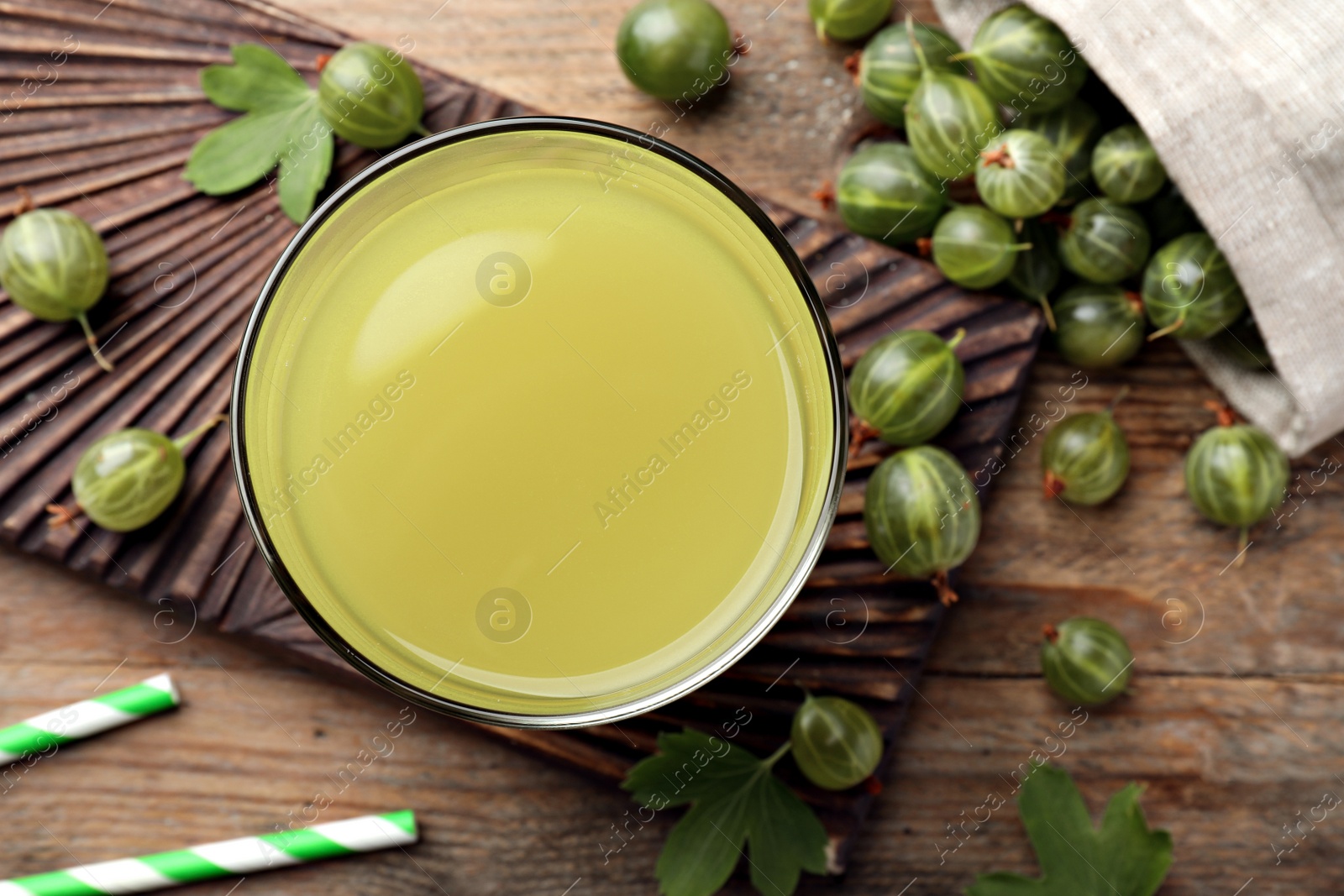 Photo of Tasty gooseberry juice and fresh berries on wooden table, flat lay