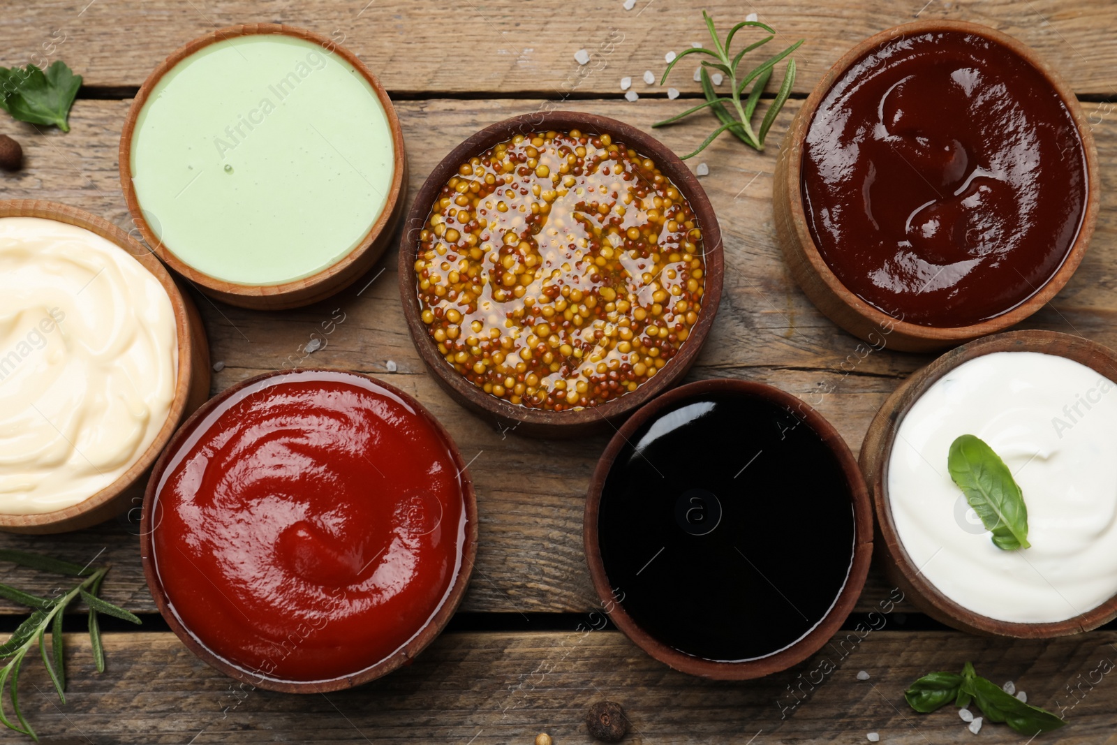 Photo of Many different sauces on wooden table, flat lay
