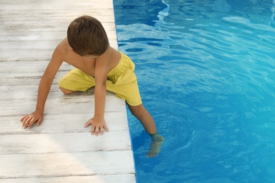 Little child near outdoor swimming pool. Dangerous situation