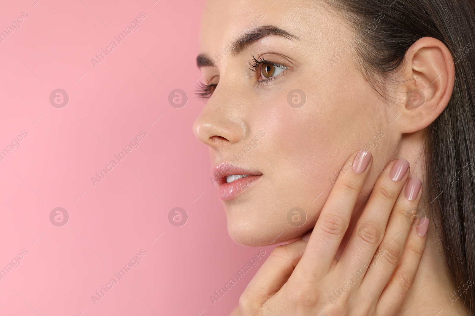 Photo of Beautiful young woman with healthy skin on pink background, closeup. Space for text