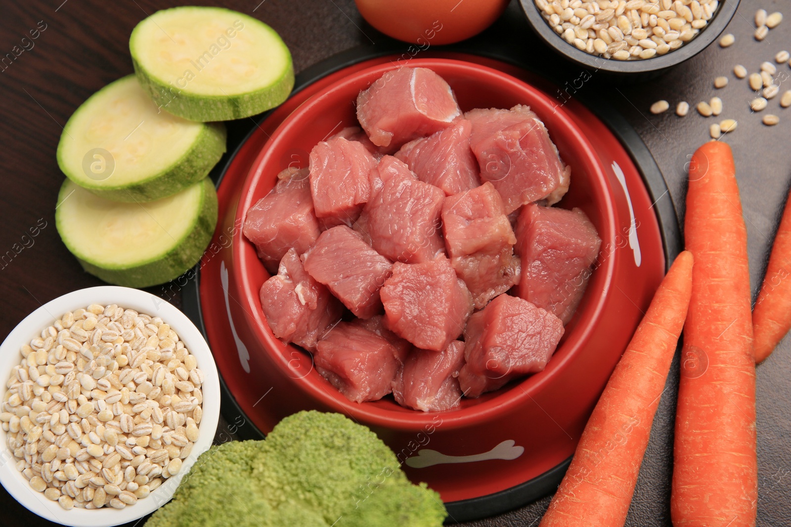 Photo of Raw meat in bowl and healthy products for pet on black background, flat lay