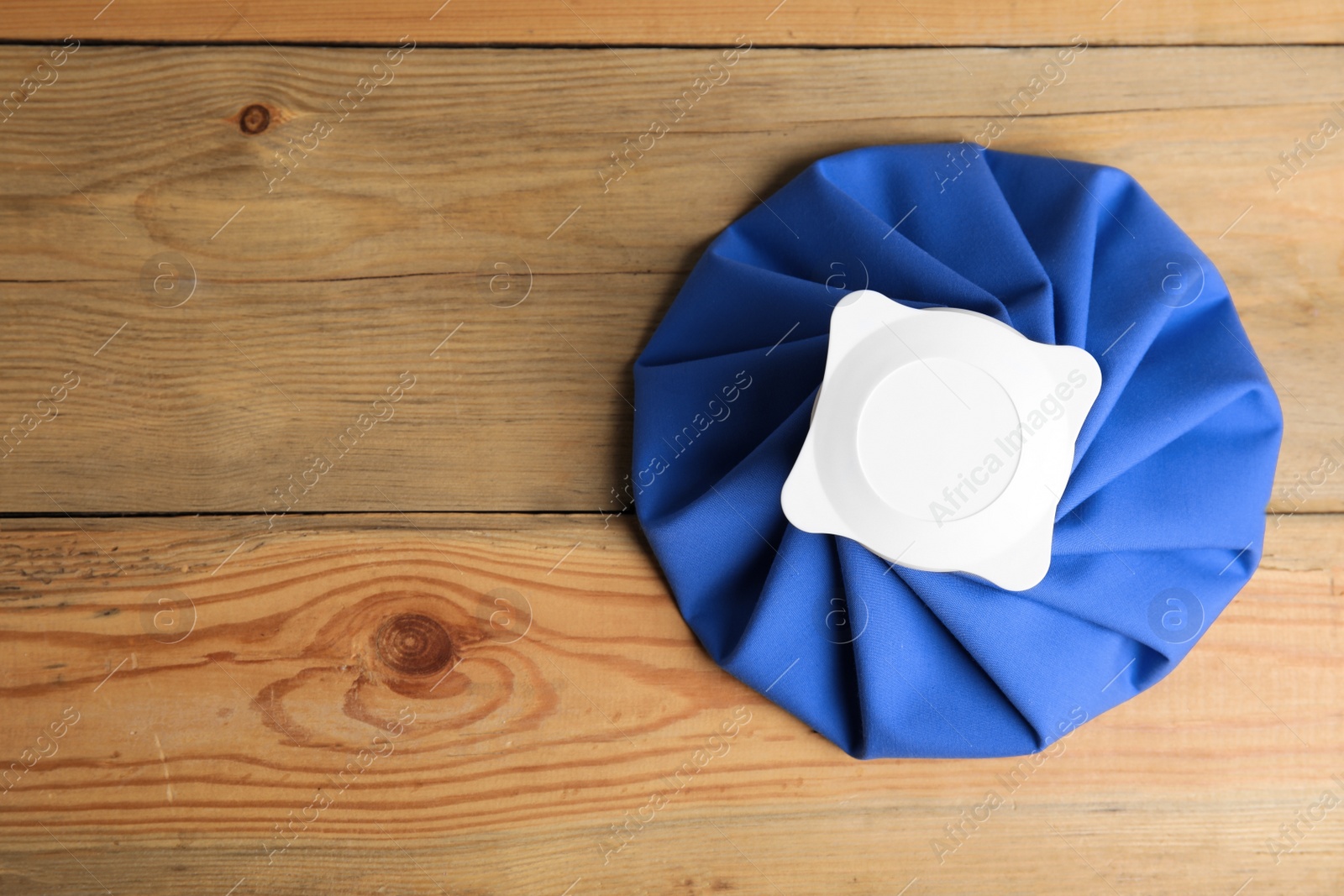 Photo of Ice pack on wooden table, top view. Space for text