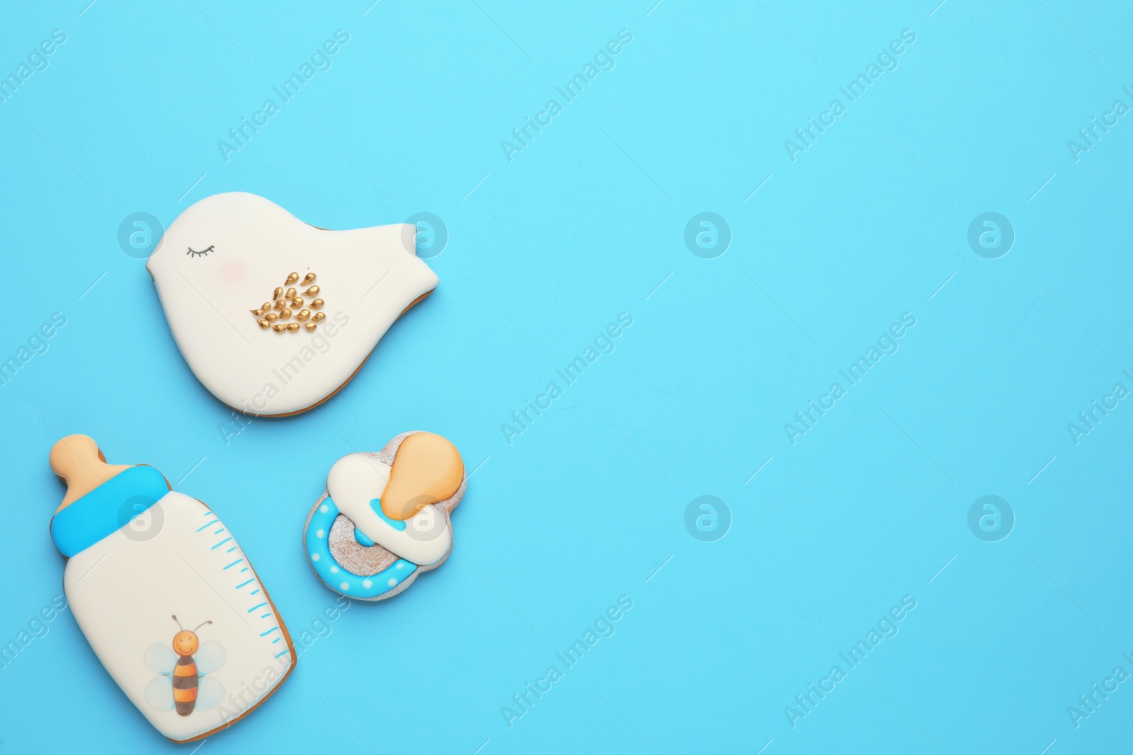 Photo of Cute tasty cookies of different shapes on light blue background, flat lay with space for text. Baby shower party