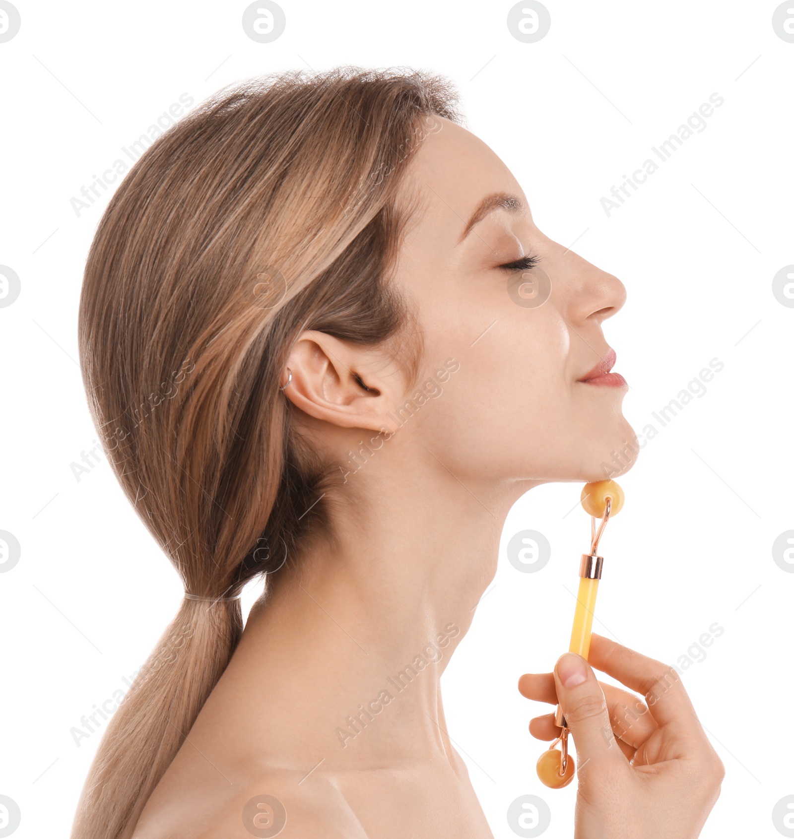 Photo of Young woman using natural jade face roller on white background