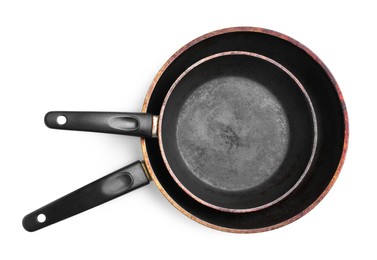 Dirty old frying pans on white background, top view