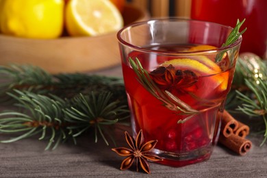 Photo of Aromatic punch drink and fir tree branch on wooden table, closeup. Space for text