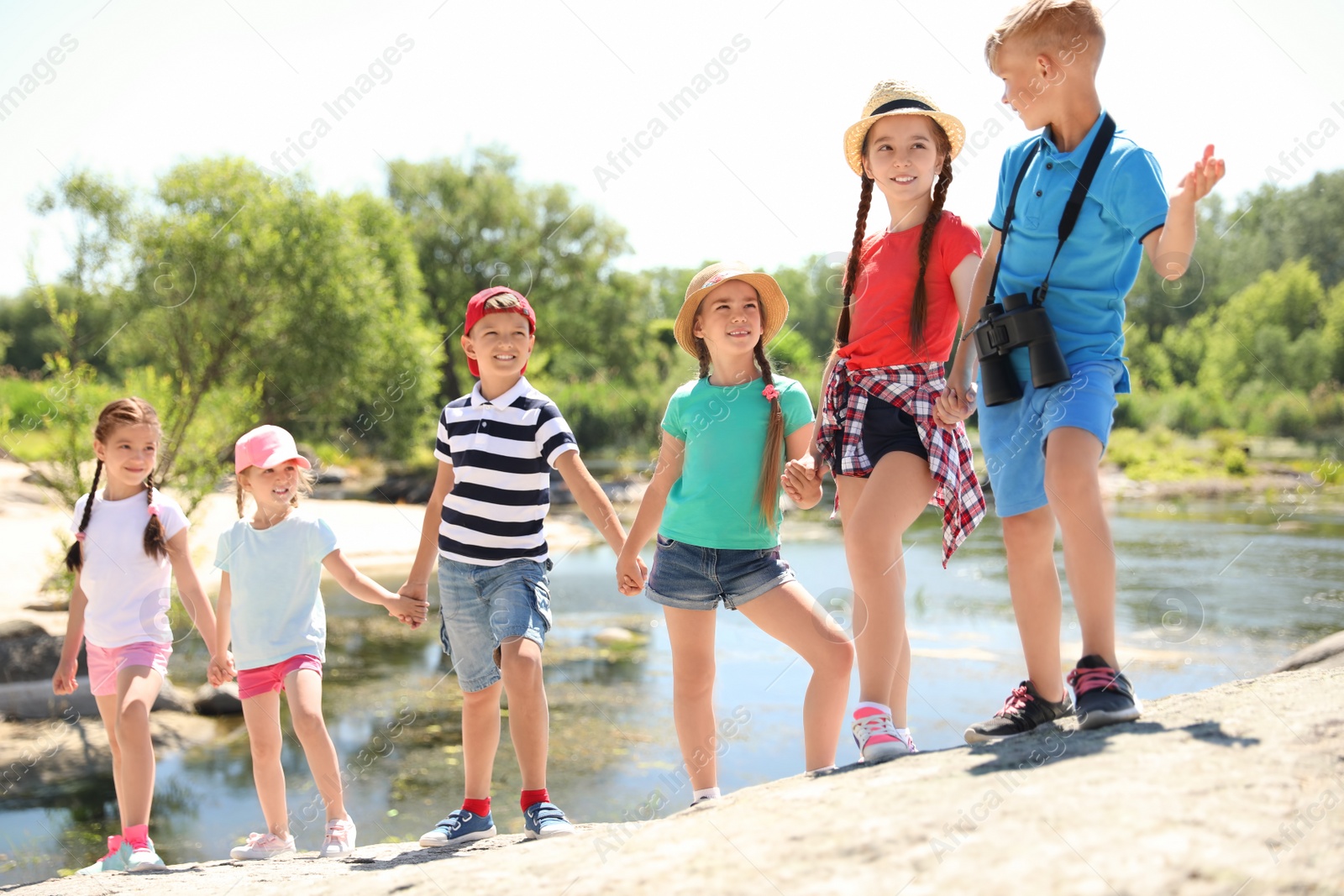 Photo of Little children with binoculars outdoors. Summer camp
