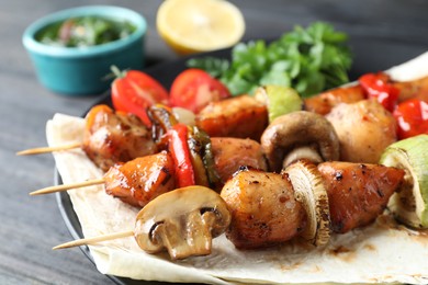 Photo of Delicious shish kebabs with vegetables served on table, closeup