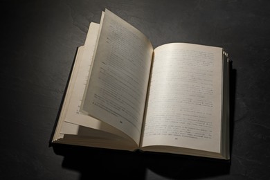Photo of Open hardcover book on black textured table