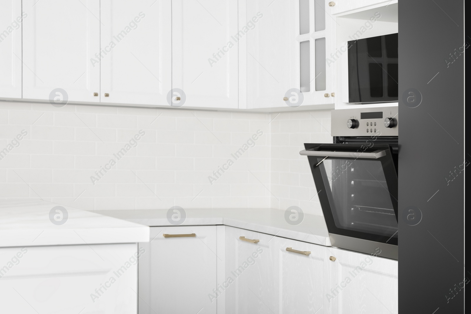 Photo of Modern oven and microwave in white clean kitchen