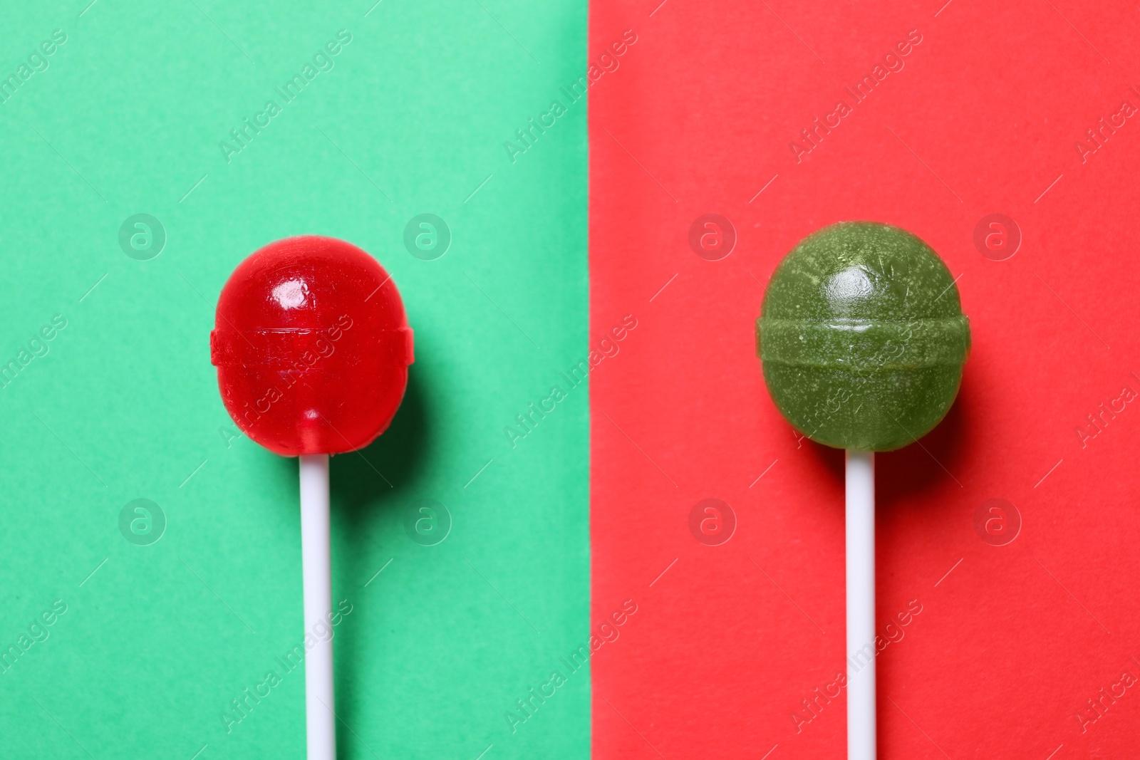 Photo of Two lollipops on color background, flat lay