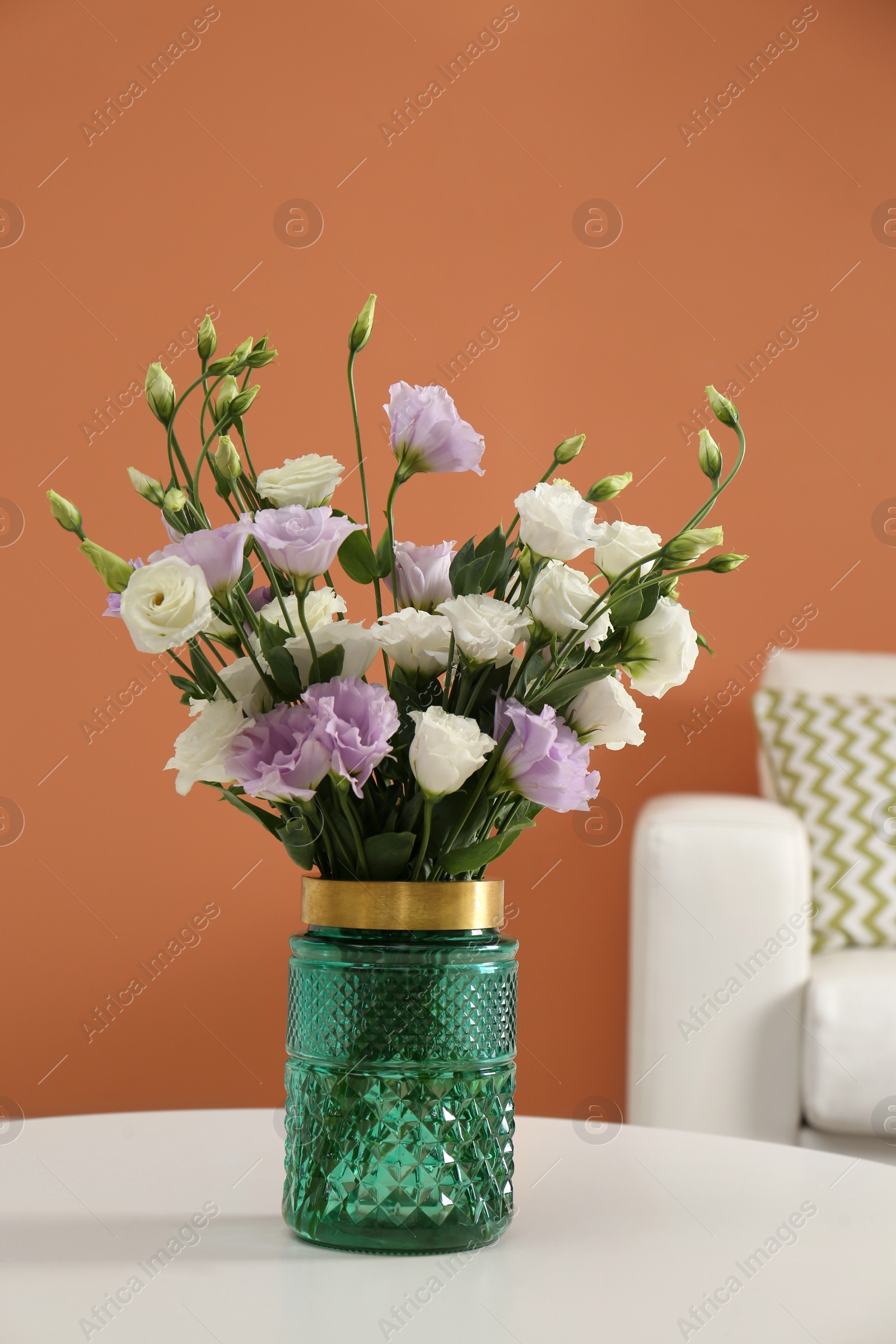 Photo of Bouquet of beautiful Eustoma flowers on table in living room