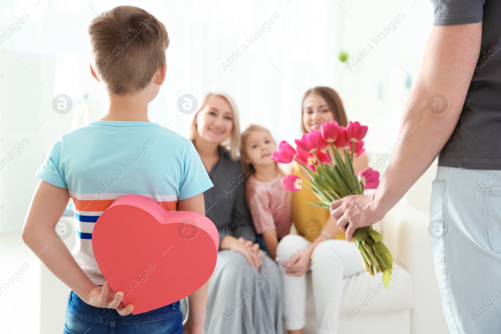 Photo of Little boy and his father congratulating their family at home