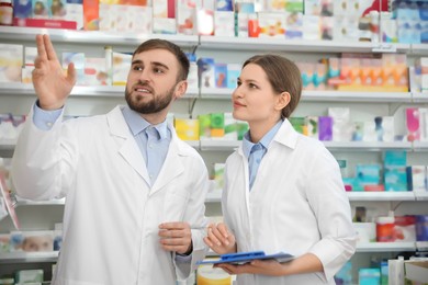 Professional pharmacists working together in modern drugstore