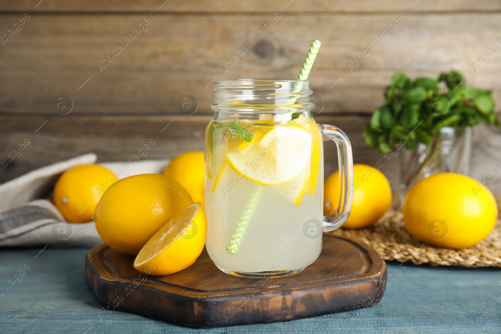Photo of Cool freshly made lemonade and fruits on light blue wooden table