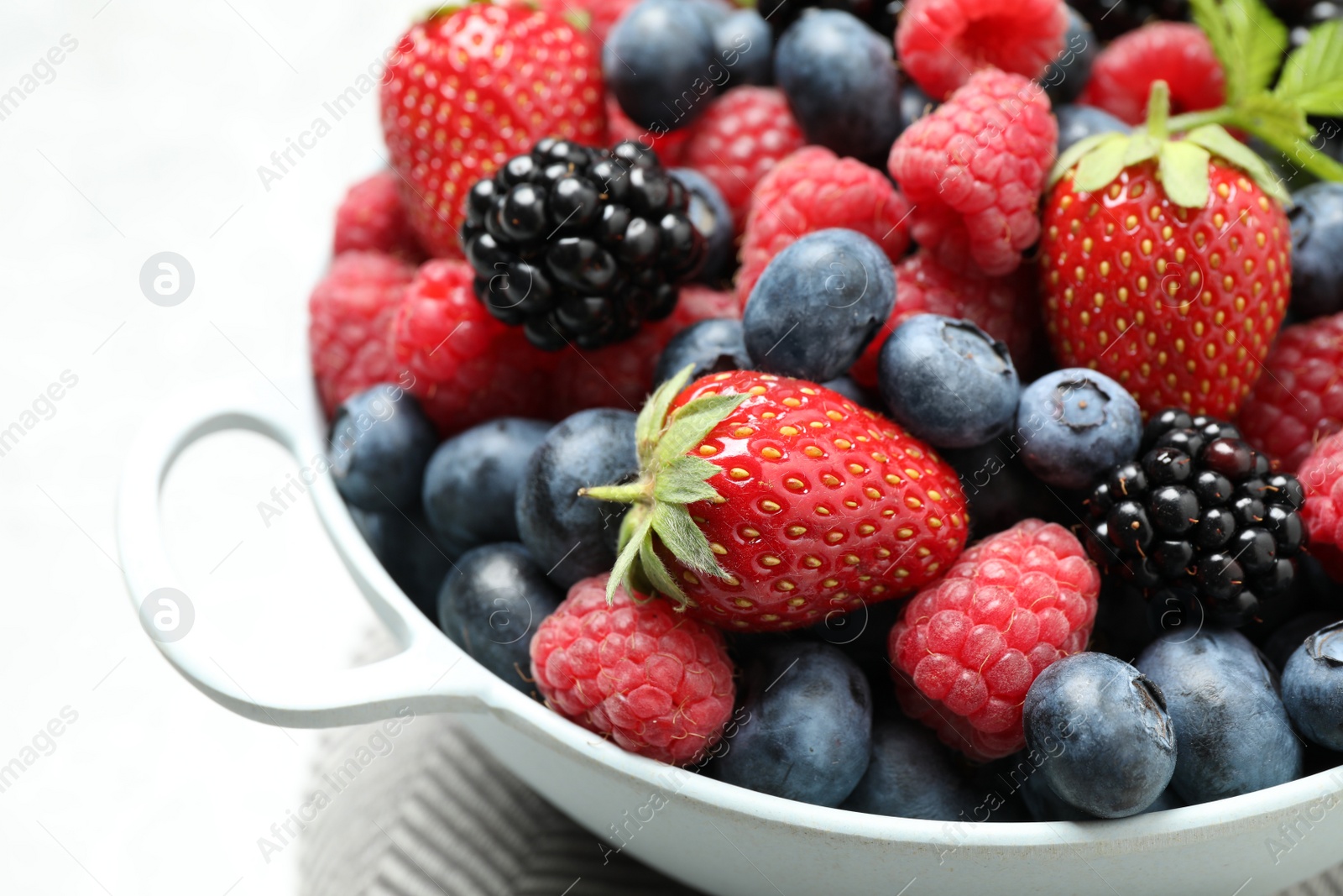 Photo of Mix of ripe berries in bowl, closeup