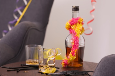 Messy table with glasses and bottle after party indoors