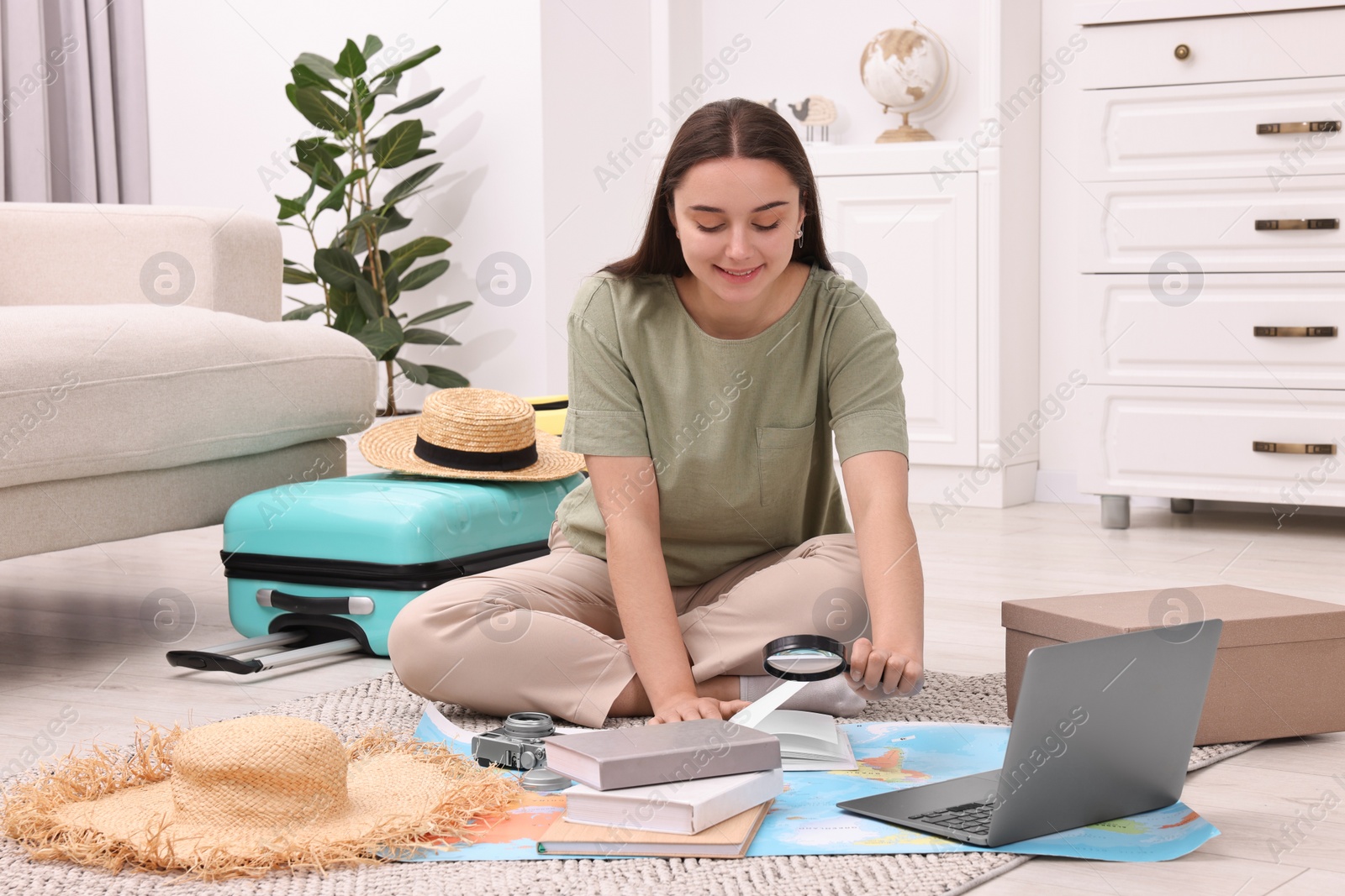 Photo of Travel blogger with magnifying glass and map planning trip at home