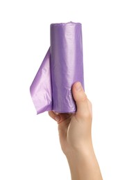 Photo of Woman holding roll of violet garbage bags on white background, closeup. Cleaning supplies