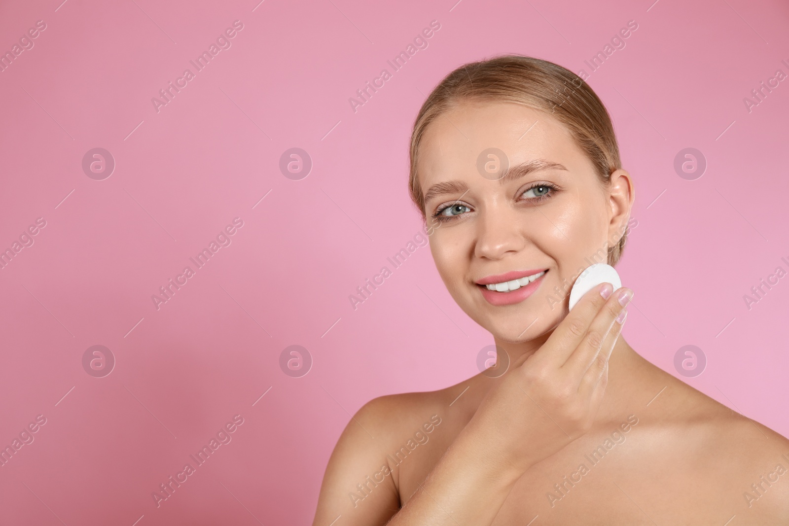 Photo of Beautiful young woman with cotton pad on pink background. Space for text